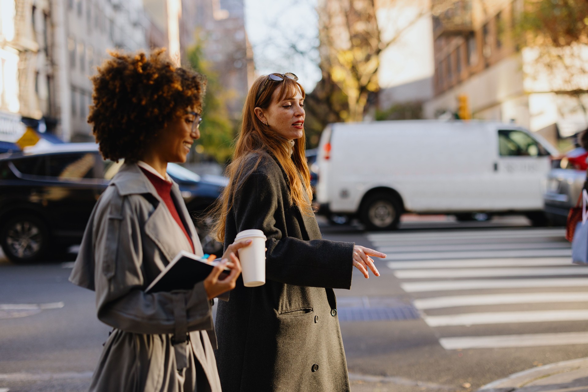 Two Businesswomen Walking with Coffee and Notebook in New York City