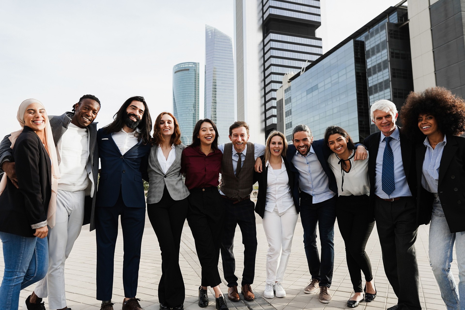 Multiethnic business people celebrating outdside of the office with city in background